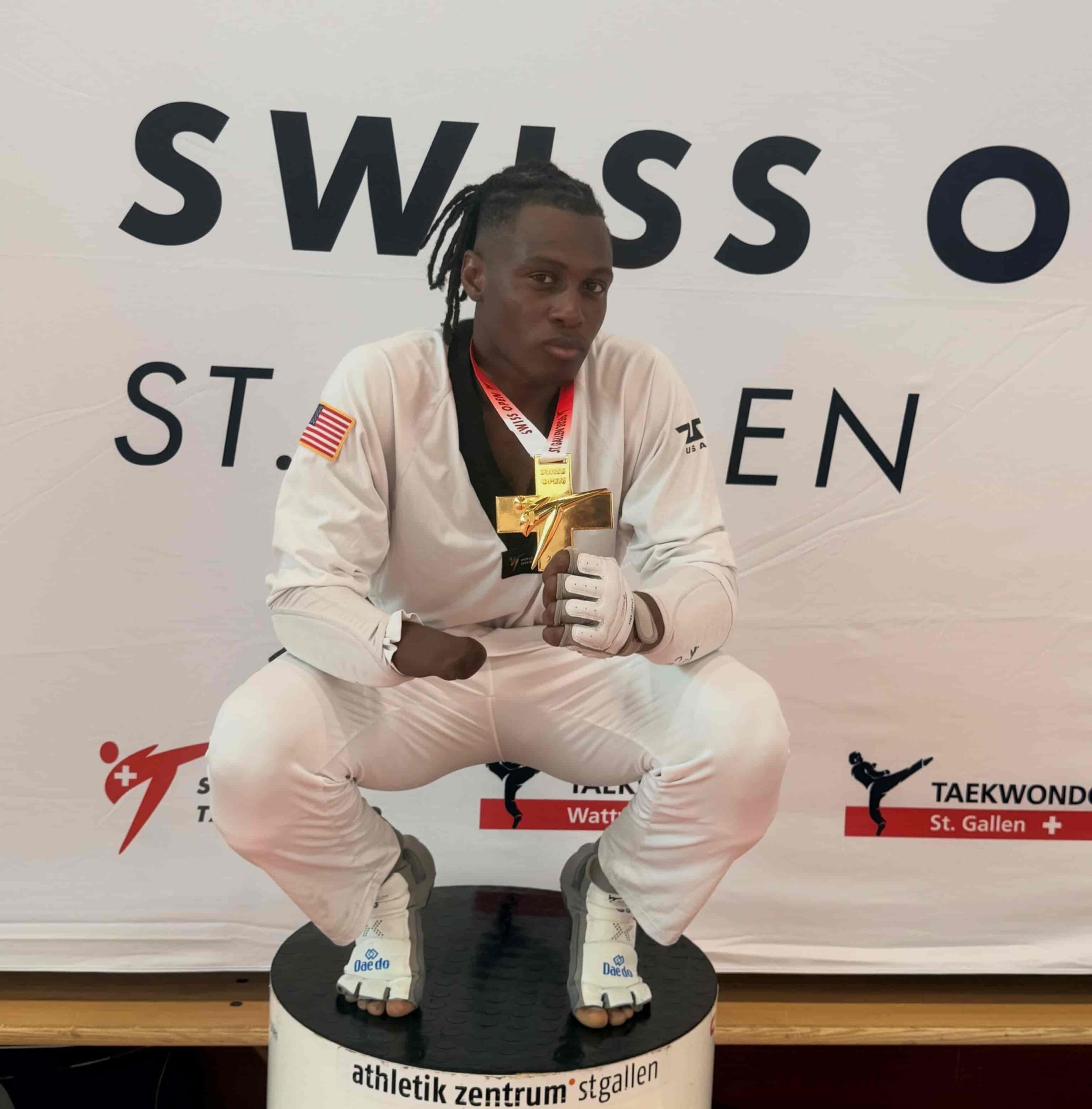 Ismael Ox con uniforme de taekwondo mostrando una medalla en forma de cruz.