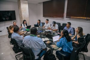 Funcionarios de ambos departamentos reunidos en una gran mesa.