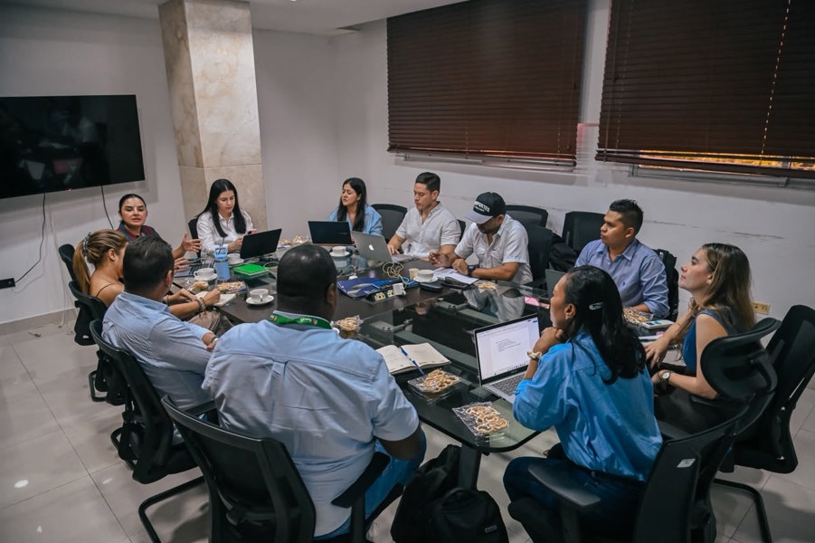 Funcionarios de ambos departamentos reunidos en una gran mesa.