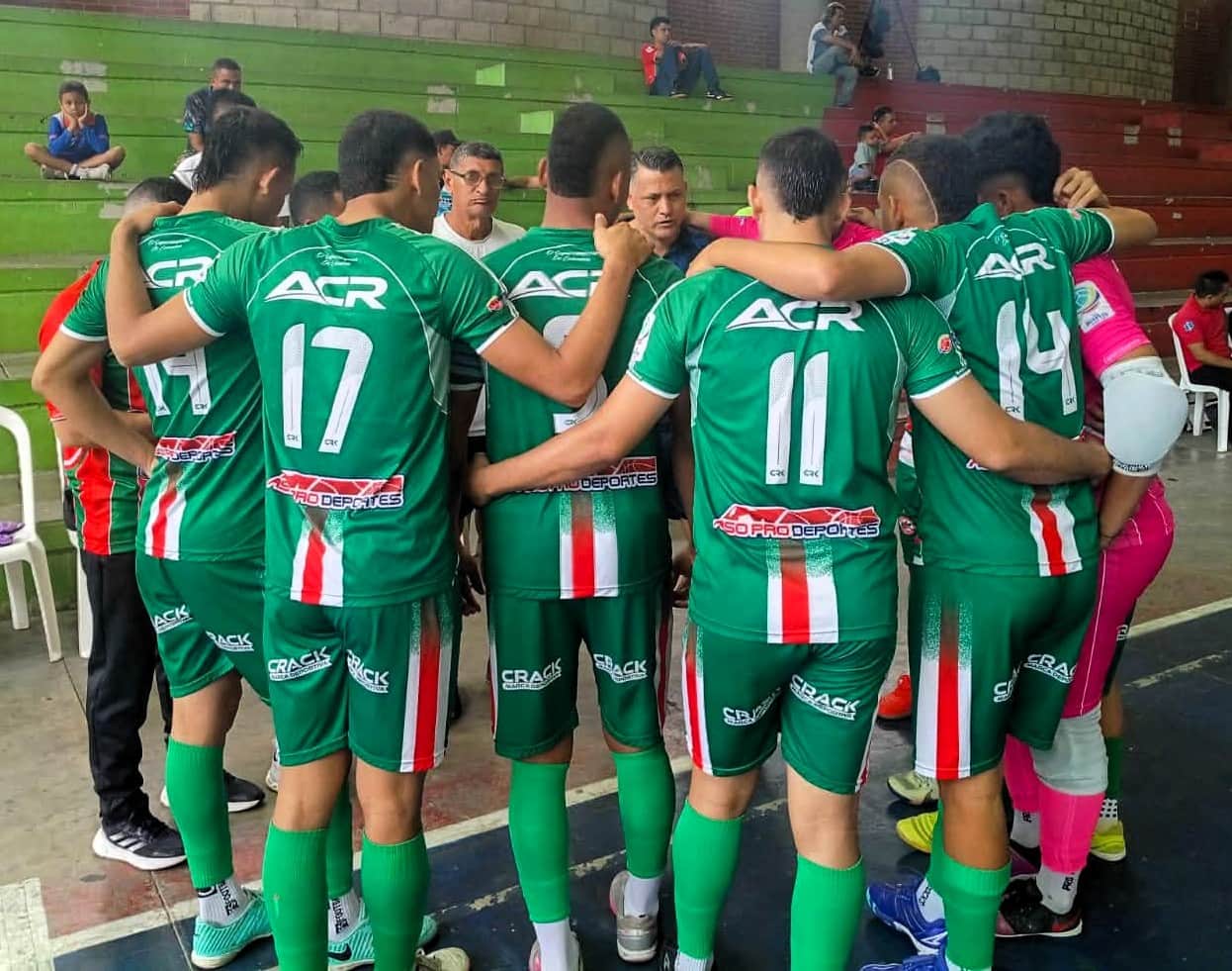 El grupo completo reunido en ronda orando.
